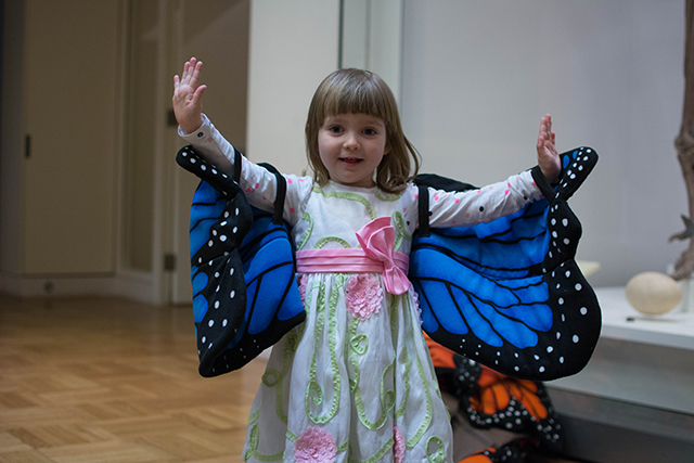 A young girl poses with butterfly wings in the Schad Gallery. Photo by Fatima Ali