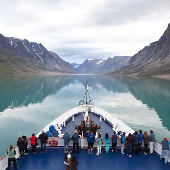 A view from the bow of the C3 Expedition ship of water bordered on both left and right by walls of rock in the Canadian Arctic. Photo Credit Lee Narraway