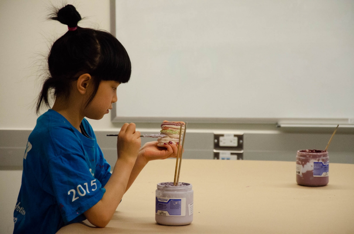 A student paints her ceramic pot in class. Image: Michael Berger
