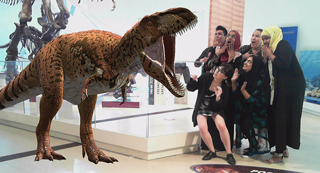 Photo of the youth cabinet next to a T. rex!